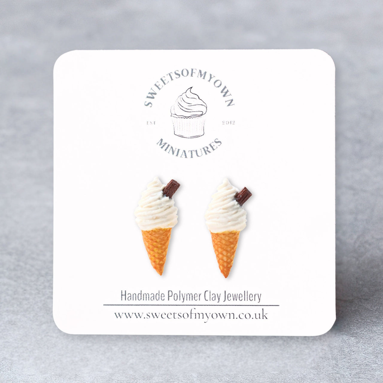 Ice cream cone earrings on a branded card with a gray background