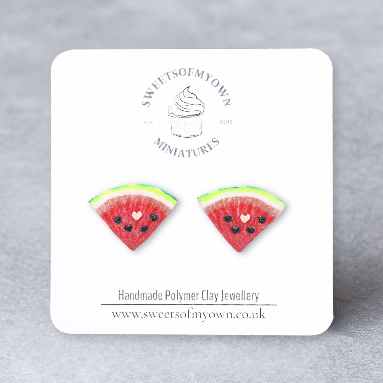 Watermelon slice earrings on a Sweetsofmyown card with a gray background.