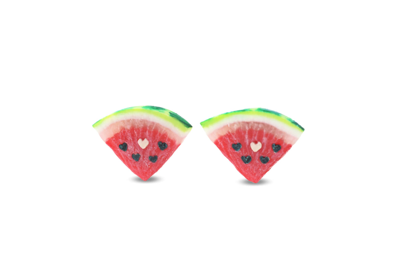 A pair of watermelon slice stud earrings with heart seeds, standing upright, made of polymer clay, displayed against a white background.