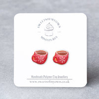 Thumbnail for Red Coffee Cups Stud Earrings with a white snowflake design that is on a SweetsOfMyOwn backing card.