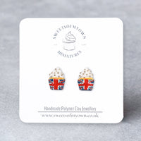 Thumbnail for Cupcake-shaped earrings with Union Jack design on a branded card against a gray background